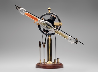 Geissler tube rotator [with modern tube], late 19th century. James W. Queen & Company, Philadelphia, brass, mahogany, lacquer, glass, resin, iron, wire. Courtesy of Mark McElyea. L2021.1301.004a–b