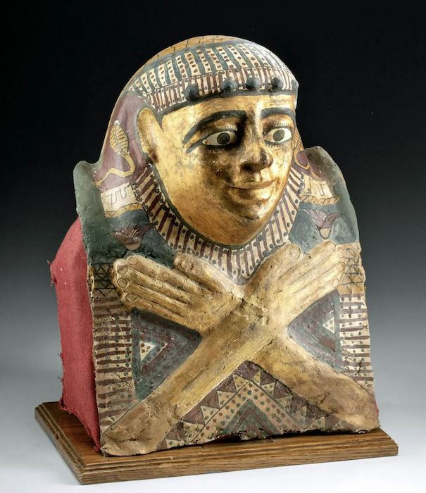 Egyptian Ptolemaic period (circa 332-30 BCE) cartonnage (mummy mask) for a male child, imported wood layered with gesso and linen with painted facial characteristics and additional linear and stippled motifs. Size on included wood display stand: 17in high by 12in wide. Cf. The British Museum. Provenance: Maryland private collection, Artemis Gallery June 20, 2018 auction; Texas private collection. Est. $9,000-$13,000. Courtesy of Artemis Gallery