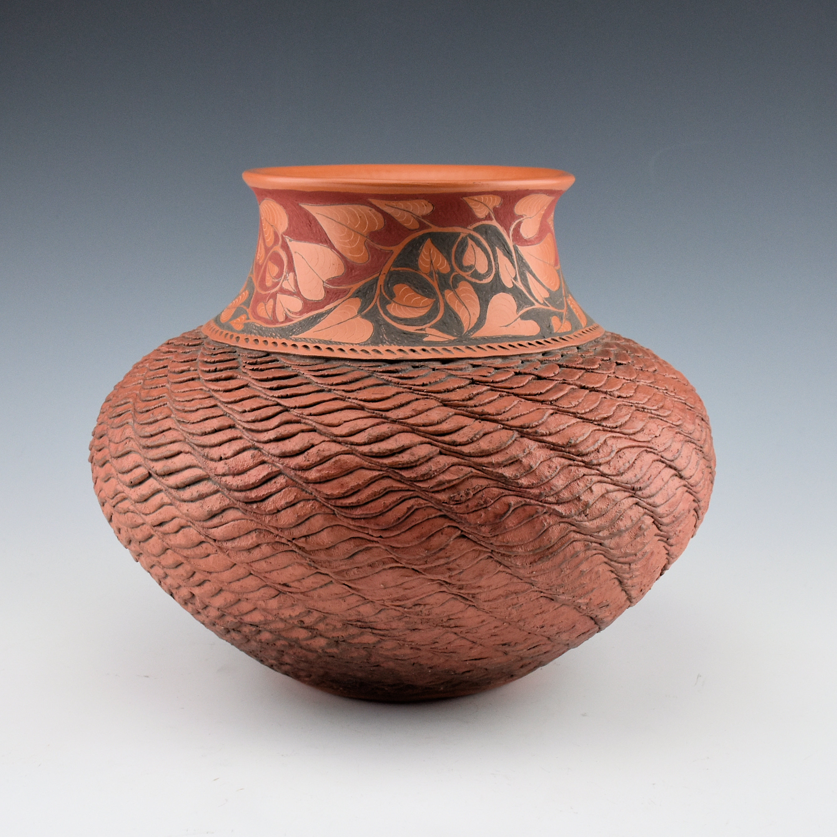 This circa-2000s corrugated jar that also has incised and painted leaves running around its shoulder represents an unusual design for Richard Zane Smith. Image courtesy of King Galleries.