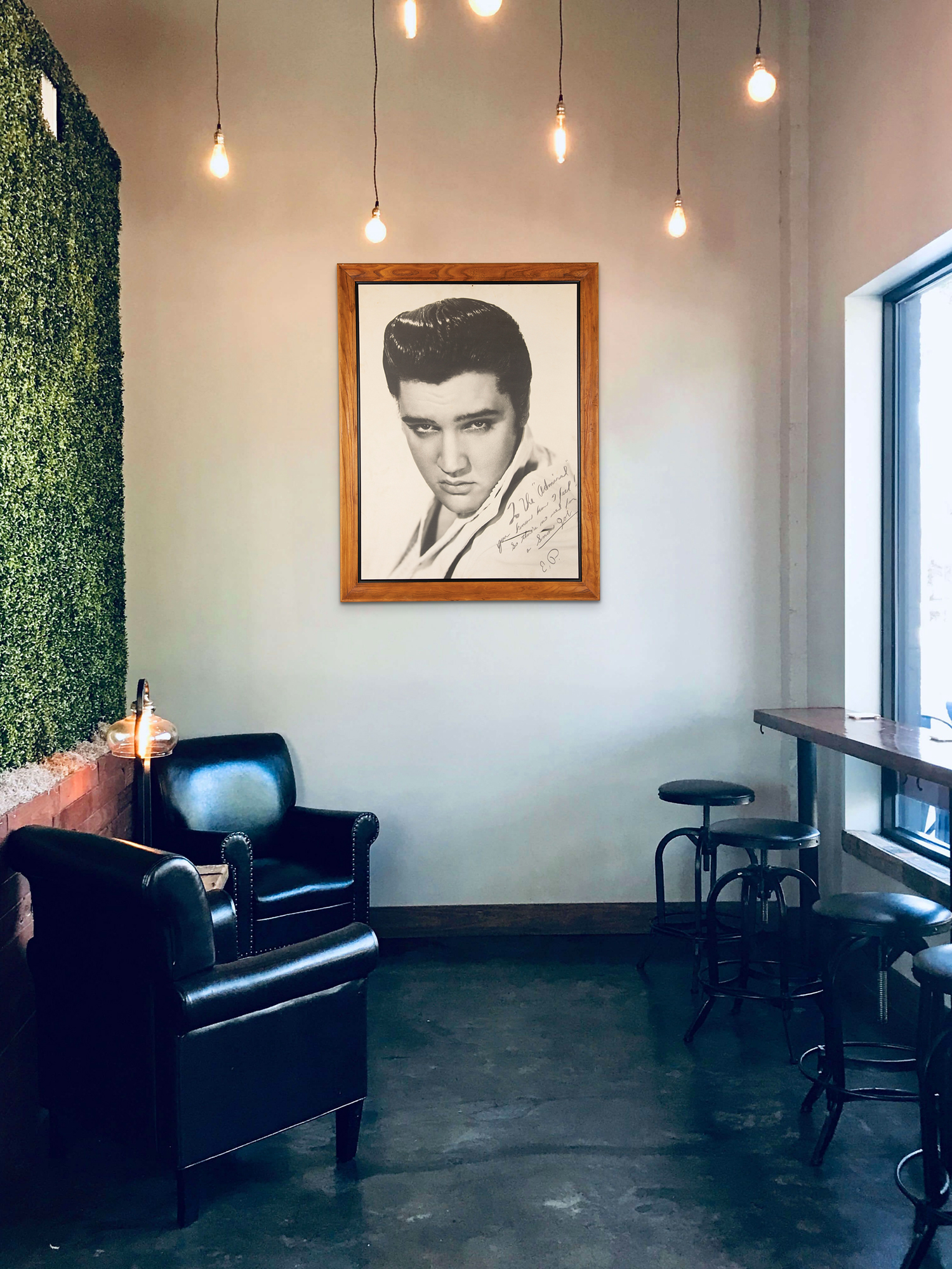 An in situ view of a massive close-up portrait of Elvis Presley, inscribed to Colonel Tom Parker, est. $15,000-$20,000