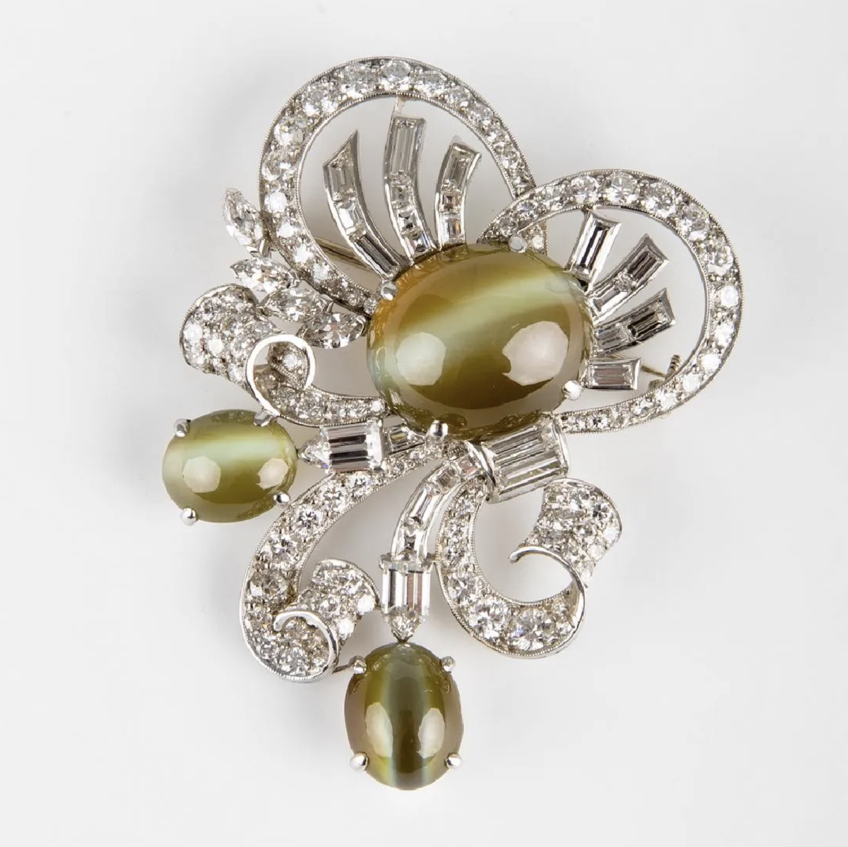A Raymond Yard bow-form diamond and platinum brooch with three cat’s eye chrysoberyls made $57,500 plus the buyer’s premium in February 2018. Image courtesy of Abell Auction and LiveAuctioneers.