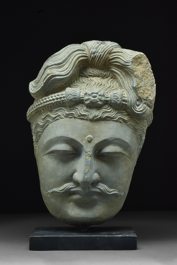 Masterfully carved Gandharan grey schist head of Bodhisattva displaying ultimate in Kushan artistry, circa 200-300 AD. Size: 310mm (12.2in) high; 9.75kg (21lbs 8oz). Provenance: London private collection, acquired early 2000s in Belgium; 1970s European collection. Estimate: £3,000-£6,000 ($3,485-$6,970). Image provided by Apollo Art Auctions, London