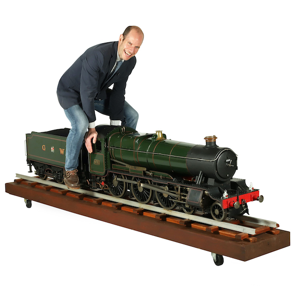Ethan Miller poses with the 7¼-in gauge steam locomotive model that brought $15,340 plus the buyer’s premium at Miller & Miller's September 2021 auction. Image courtesy of Miller & Miller and LiveAuctioneers. Price converted to US dollars.