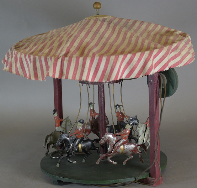 Circa-1900 Ride Around the Carousel, tinplate, with mounted horse-and-rider toys that rotate if connected to steam or other power source. Sold for $6,600