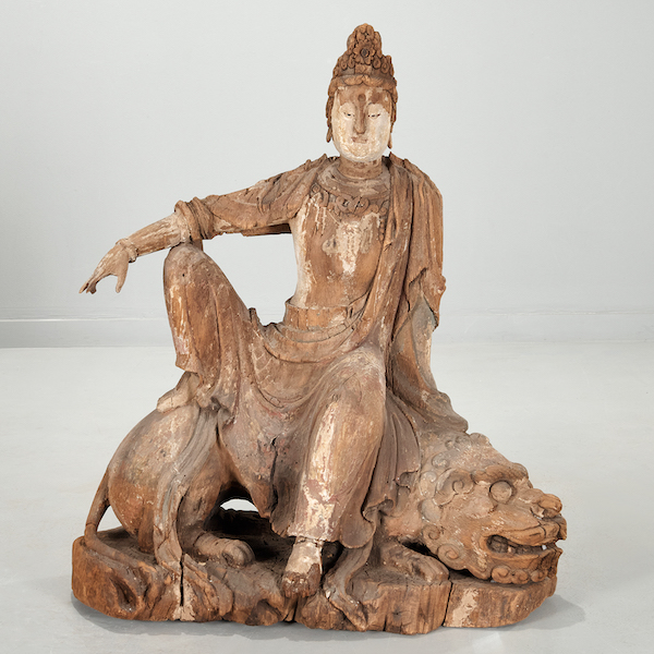 Wooden carving of Guanyin seated on a Buddhist lion, estimated at $2,500-$3,500