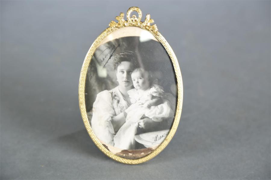 Framed, oval photograph signed by Tsaritsa Alexandra Feodorovna, showing her holding TsesarevichAlexei as a baby in 1904 (and later also signed by TsesarevichAlexei as well), estimated at $4,000-$6,000. Image courtesy of Quinn’s Auction Galleries