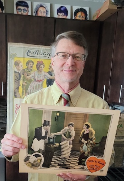In this December 2022 photo, collector Dwight Cleveland holds a lobby card from his extensive collection. He has entered an agreement with Dartmouth College to digitize his silent movie-era lobby cards for preservation and publication. Image courtesy of Dwight Cleveland.