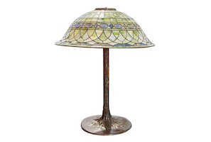Tiffany Studios table lamp with bronze tree trunk-form base, estimated at $8,000-$10,000. Image courtesy of Abell Auction Co.