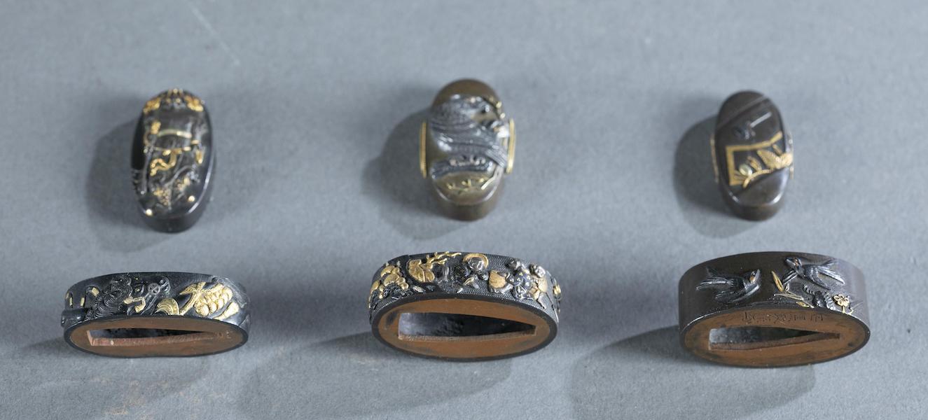 Group of three sets of Japanese Fuchi Kashira, each highly decorated and carved with accents of gold and copper, to be sold as one lot. Bottom of ‘Swallow’ Fuchi has signature of Ishiguro Masayasu. Estimate: $200-$400. Image courtesy of Quinn’s Auction Galleries