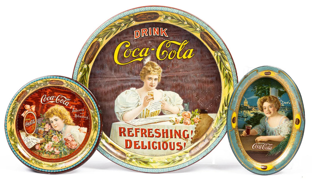 A lot of classic-era Coca-Cola trays containing one round, one oval tip tray and one round tip tray, offered with an estimate of $600-$1,500, ultimately sold for $3,200 plus the buyer’s premium in May 2021. Image courtesy of Ida and Larry Goldberg Coins & Collectibles and LiveAuctioneers