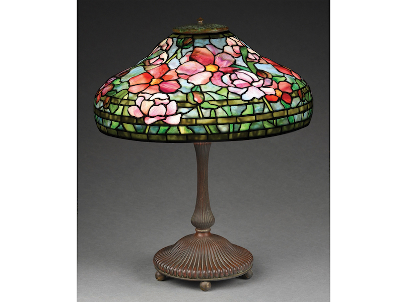 Tiffany Studios Peony leaded-glass table lamp in vibrant color scheme dominated by red and pink blooms with yellow centers. Sold above high estimate for $79,950. Image courtesy of Morphy Auctions