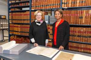 Lynda Roscoe Hartigan, PEM’s Rose-Marie and Eijk van Otterloo Executive Director and CEO (left), and Supreme Judicial Court Chief Justice Kimberly S. Budd (right) examine the Witch Trial documents from 1692. Image courtesy of PEM. Photo by Kathy Tarantola.