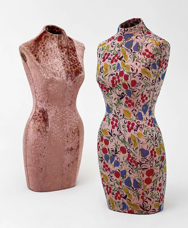 Geoffrey Beene mannequins, set of two, one clad in a plush pink crushed velvet fabric with floral motifs, the other covered in a floral and fruit pattern fabric, estimated at $1,200-$1,800