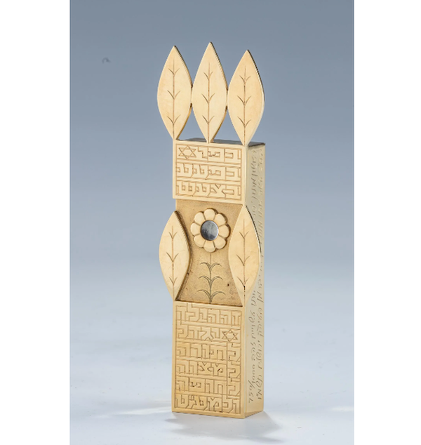 A Menachem Berman 18K gold mezuzah from 1980, featuring a child’s blessing to grow, do good deeds, learn the Torah, and marry, achieved $10,000 plus the buyer’s premium in January 2021. Image courtesy of J. Greenstein & Co., Inc. and LiveAuctioneers