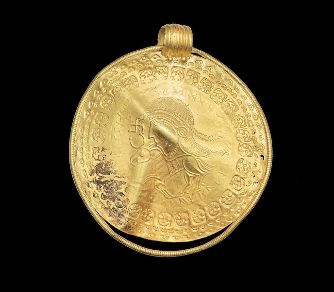 The front side of the gold bracteate with the Odin inscription. Photo credit: Arnold Mikkelsen, The National Museum of Denmark.