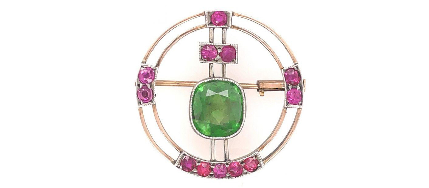 Circa-1900 pin with large demantoid garnet and ruby accents, estimated at $20,000-$24,000