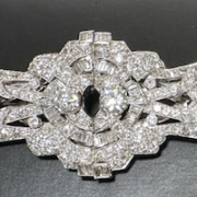 18K white gold and diamond double-clip brooch featuring two larger, old, mine-cut diamonds each weighing approximately .65 carats, 9H-I color, VS2 clarity; 136 round diamonds weighing approximately 2.9 carats, and 28 baguettes weighing approximately .50 carats. Total diamond weight is 4.70 carats, and the brooch has a total weight of 31.1g. Estimate $3,000-$4,000