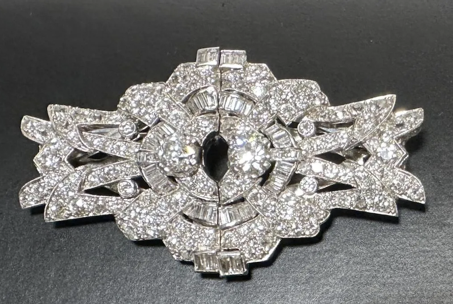 18K white gold and diamond double-clip brooch featuring two larger, old, mine-cut diamonds each weighing approximately .65 carats, 9H-I color, VS2 clarity; 136 round diamonds weighing approximately 2.9 carats, and 28 baguettes weighing approximately .50 carats. Total diamond weight is 4.70 carats, and the brooch has a total weight of 31.1g. Estimate $3,000-$4,000
