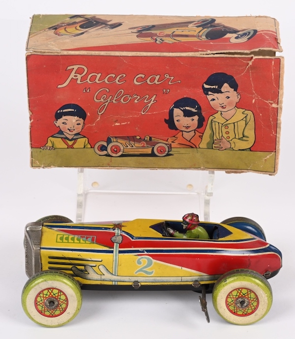 Wonderful 9in pre-WWII Japanese wind-up Race Car ‘Glory’ with full-body driver. Distinctive colors of Art Deco period. Retains original box that depicts three children with a faithful depiction of the toy car. Estimate $2,000-$3,000