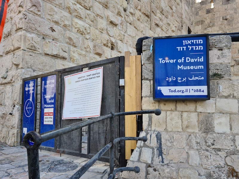 Signs directing patrons to the entrance of the Tower of David Museum in Jerusalem, photographed in September 2021. The museum has reopened following a three-year, $50 million dollar revamp project. Image courtesy of Wikimedia Commons, photo credit Sasha1506. Shared under the Creative Commons Attribution-Share Alike 4.0 International license.
