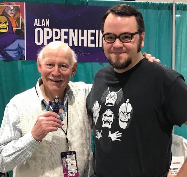At a collectibles event, Michael Bollinger (at right) poses with voice actor Alan Oppenheimer, who voiced the villain Skeletor in the original Masters of the Universe cartoon series. Oppenheimer is holding Bollinger’s childhood Skeletor action figure. Image courtesy of Michael Bollinger.