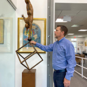 Rico Baca, auctioneer and co-owner of Palm Beach Modern Auctions, rotates a Jorge Marin sculpture on its base. The monumental kinetic bronze, estimated at $3,000-$5,000, is one of dozens of pieces from the Tupperware Brands Corporation art collection that appear in the May 6 sale. Photo credit Palm Beach Modern Auctions staff