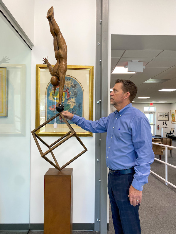 Rico Baca, auctioneer and co-owner of Palm Beach Modern Auctions, rotates a Jorge Marin sculpture on its base. The monumental kinetic bronze, estimated at $3,000-$5,000, is one of dozens of pieces from the Tupperware Brands Corporation art collection that appear in the May 6 sale. Photo credit Palm Beach Modern Auctions staff