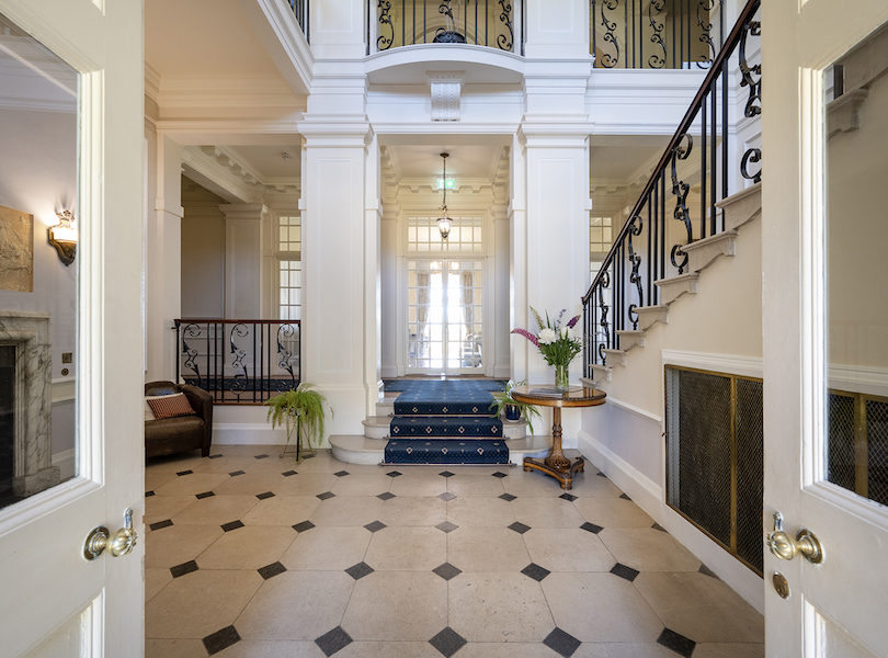 The entry hall of Bob Dylan’s Edwardian-style manor in Scotland features a limestone staircase with a wrought iron and wooden balustrade. Image courtesy of Knight Frank and TopTenRealEstateDeals.com