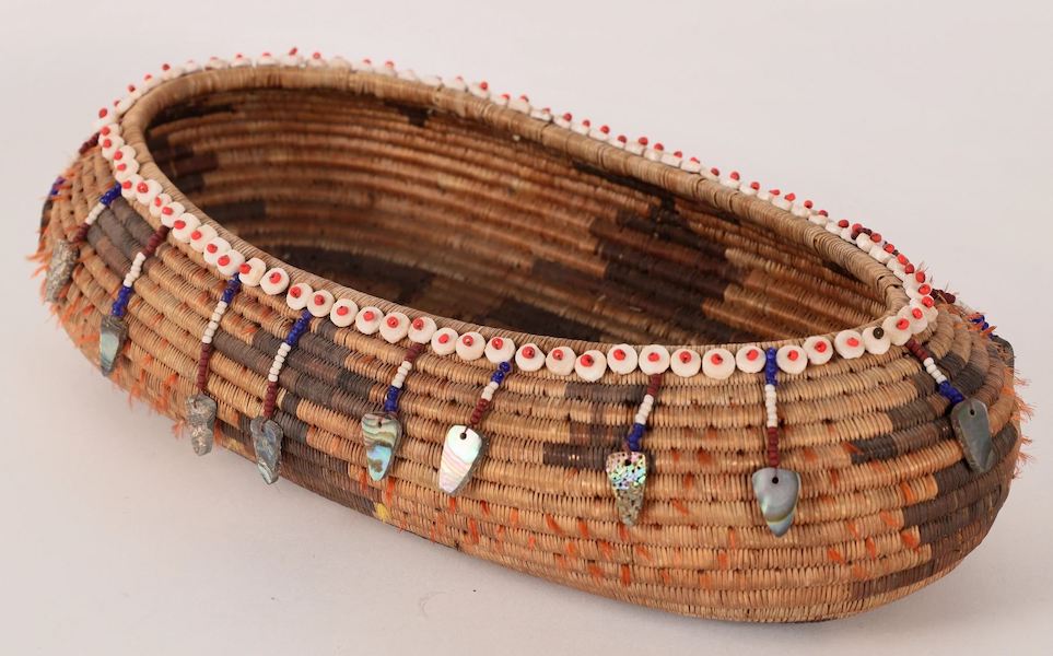 Oval Pomo gift basket featuring stepped diamonds, triangles and motifs, a rim lined with clamshell discs and glass beads, plus bead and abalone shell pendants, $4,875