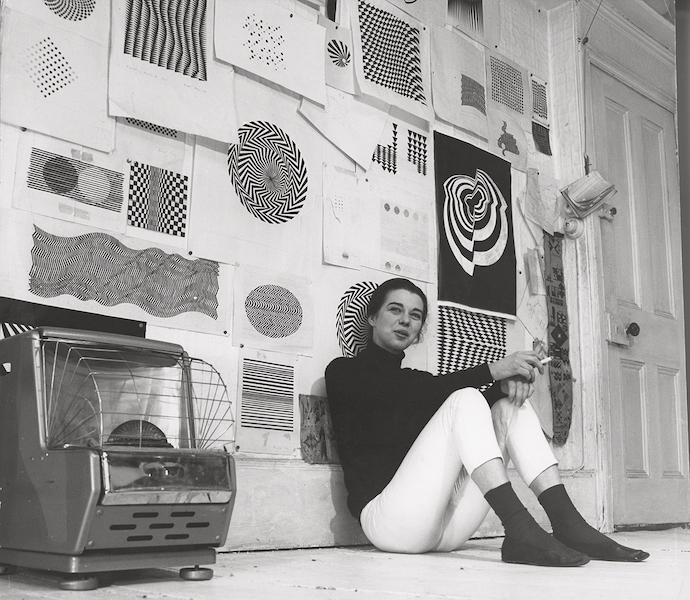 Bridget Riley with black-and-white studies in her Warwick Road studio, London, early 1960s. Photo credit: Jorge Lewinski. Private Collection / © The Lewinski Archive at Chatsworth. All Rights Reserved 2023 / Bridgeman Images. 