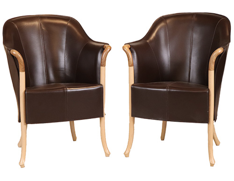 Pair of Progetti leather-upholstered barrel-back club chairs by Giorgetti, estimated at $600-$800. Image courtesy of Nye & Company Auctioneers