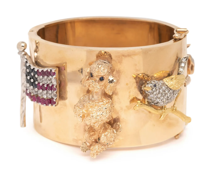 A gold charm bangle bracelet with applied charms, including an American flag, brought $2,500 plus the buyer’s premium in December 2022. Image courtesy of Hindman and LiveAuctioneers.
