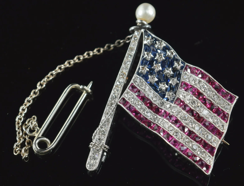A white gold diamond, ruby, and sapphire American flag pin having a pearl flag pole finial made $4,200 plus the buyer’s premium in December 2021. Image courtesy of Tremont Auctions and LiveAuctioneers.