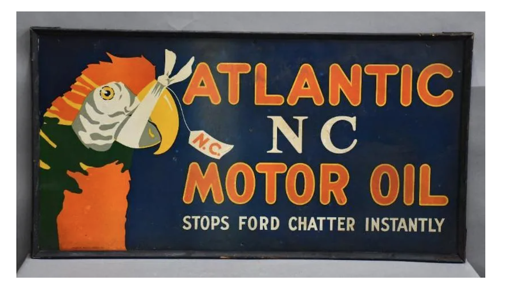 An Atlantic NC Motor Oil ‘Stops Ford Chatter Instantly’ wood-framed sign picturing a parrot flew away with $18,000 plus the buyer’s premium in April 2022. Image courtesy of Matthews Auctions, LLC and LiveAuctioneers.